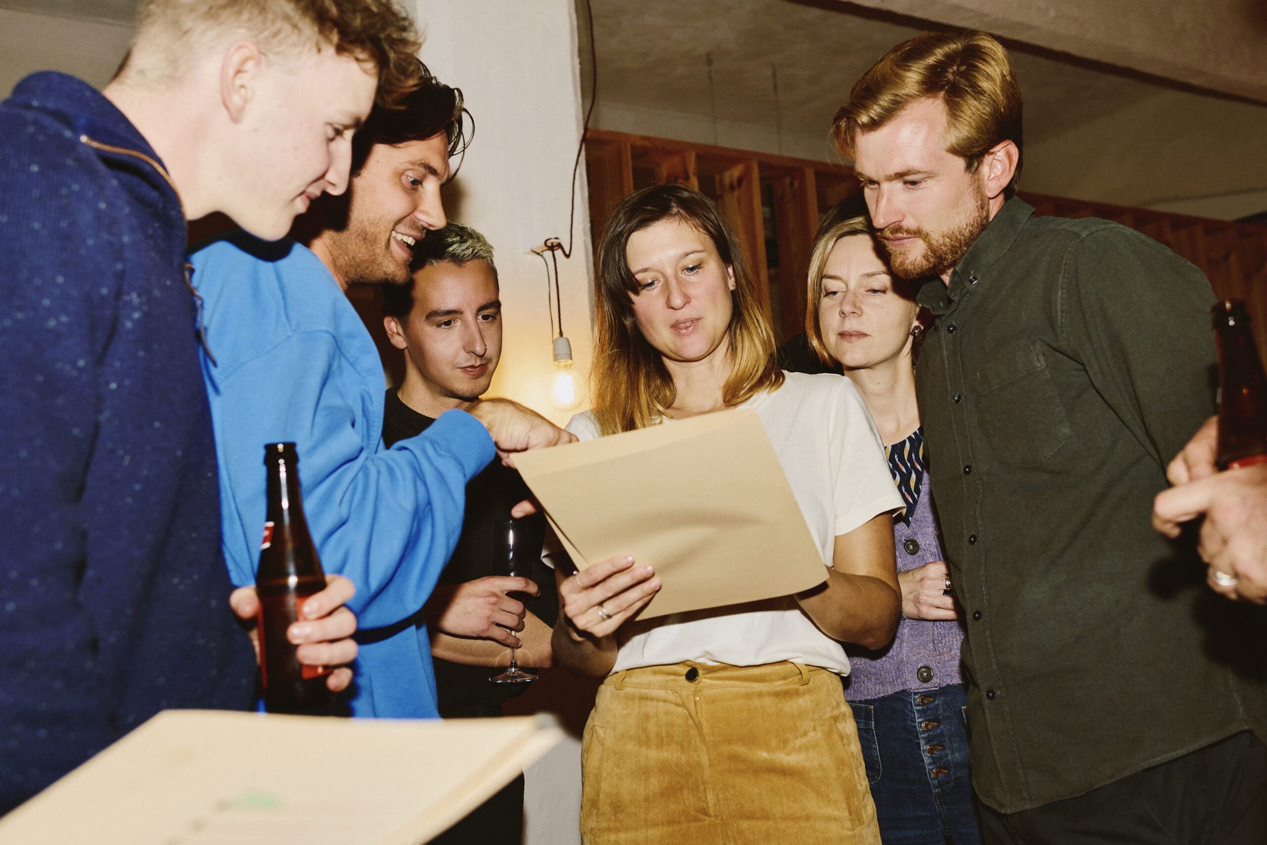 Team members gathered around reviewing packaging design work at an informal presentation